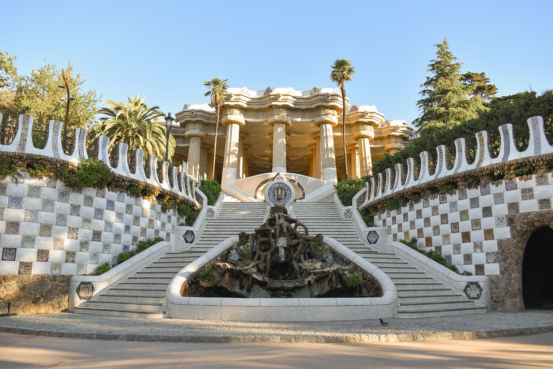 Escalinata del Park Güell hacia la sala hipóstila, con el dragón y muros de trencadís, Barcelona.
