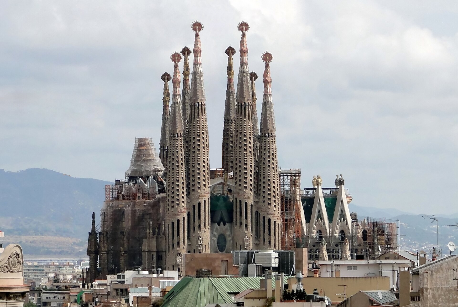 Torres de la Sagrada Familia entre tejados, con andamios y obras en curso, Barcelona.