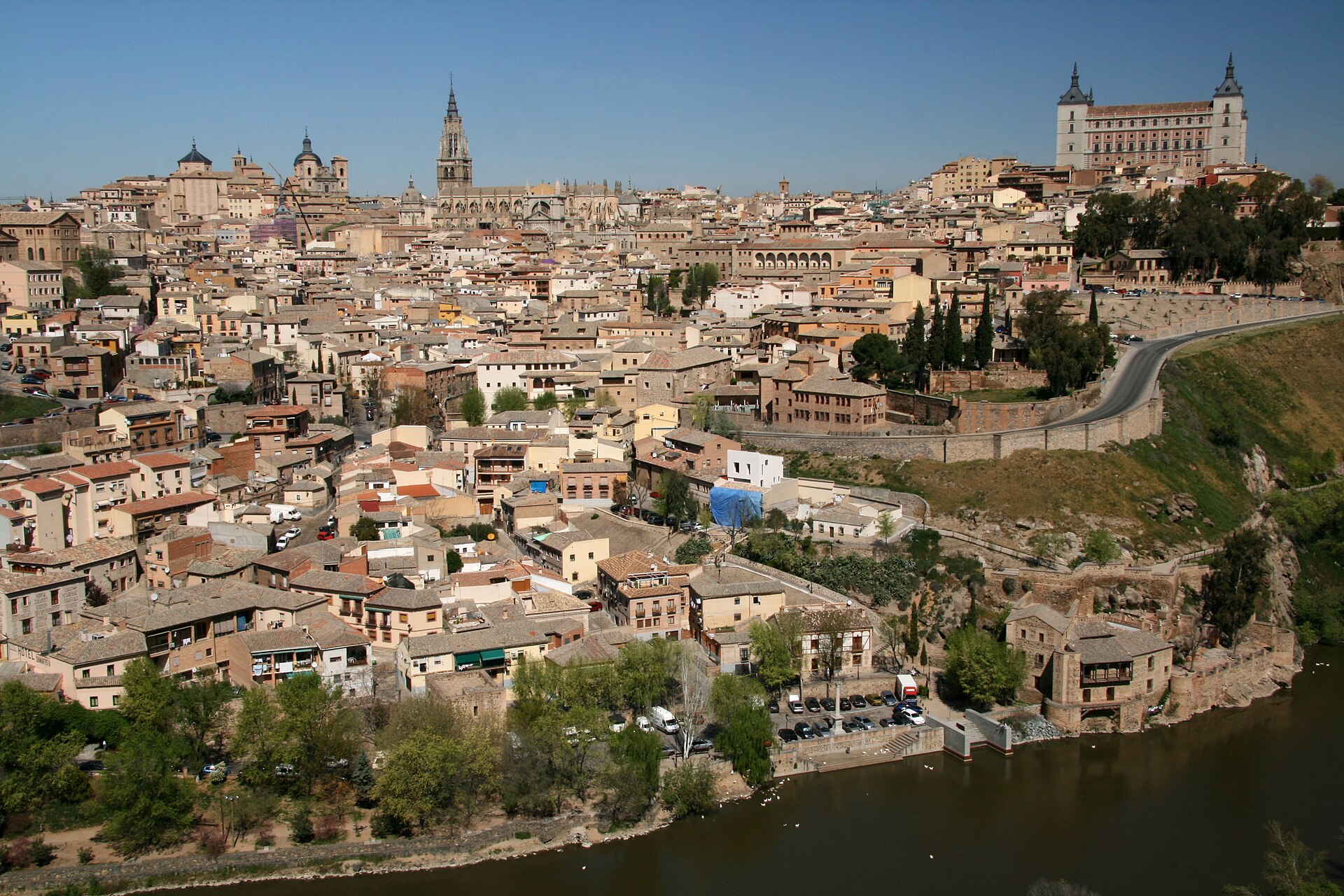 Casco de Toledo visto desde el Tajo: catedral, Alcázar y tejados, con el río en primer término.